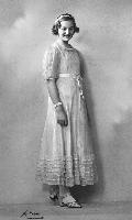 4. 1928: Almindelig grund af Gurli Høedt-Rasmussen. Billedtekst: Kjolen er min første lange kjole, beregnet til afdansningsbal og juletræ - syet af min mor.